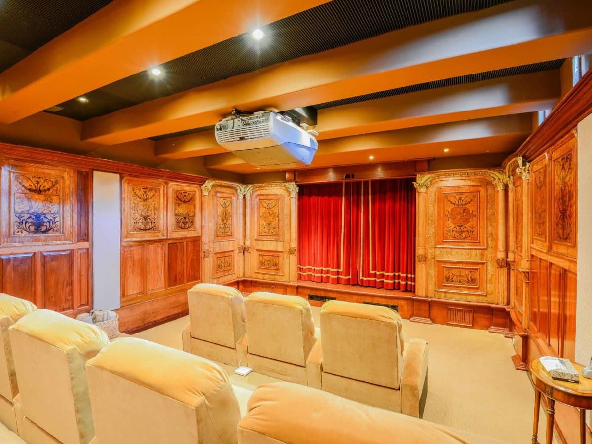 Downstairs is a custom-built movie theater with seating for seven and a projector.