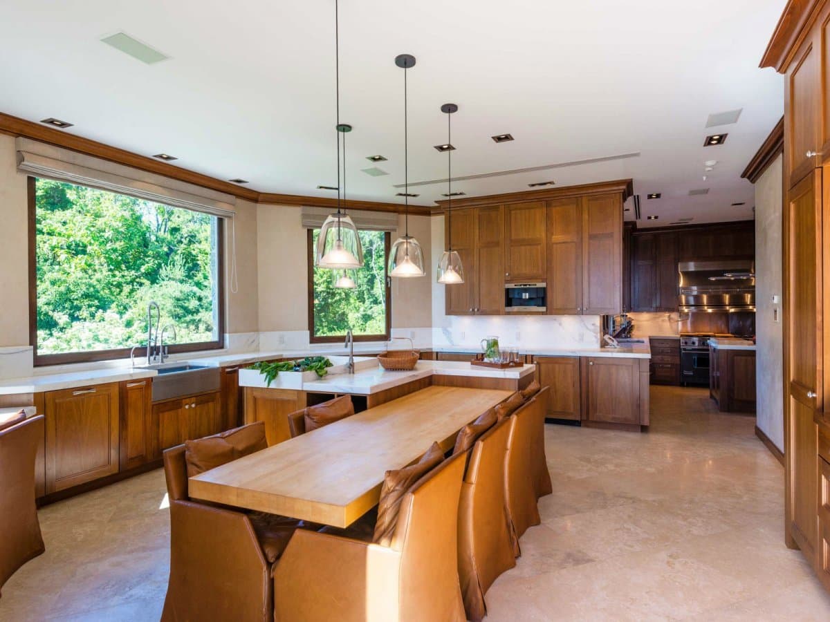 The kitchen has an island as well as long dining table.