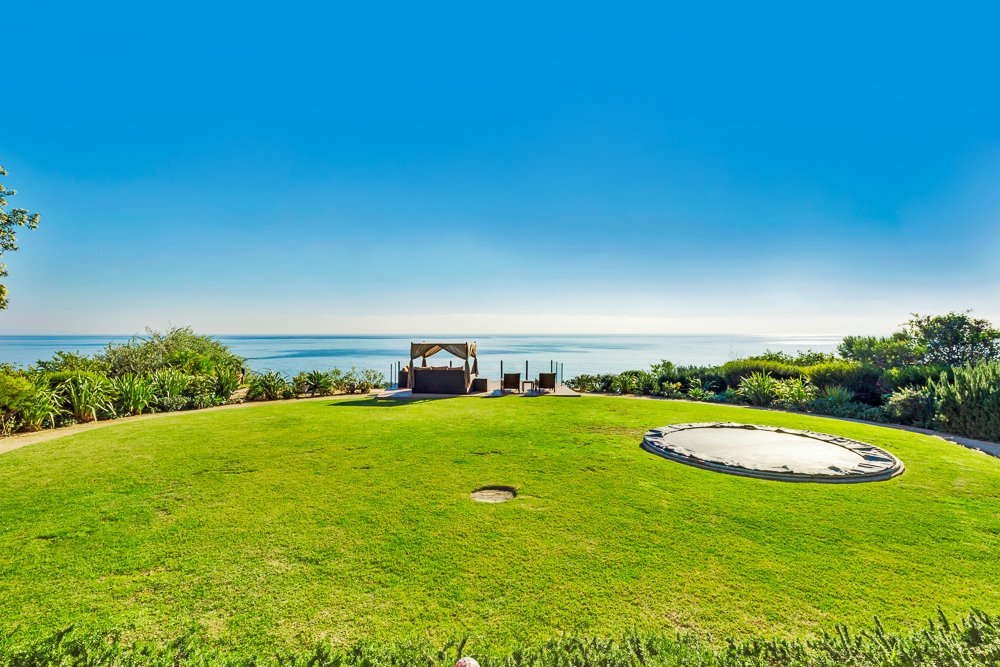 The landscaped backyard is huge with an in-ground trampoline (for safety).