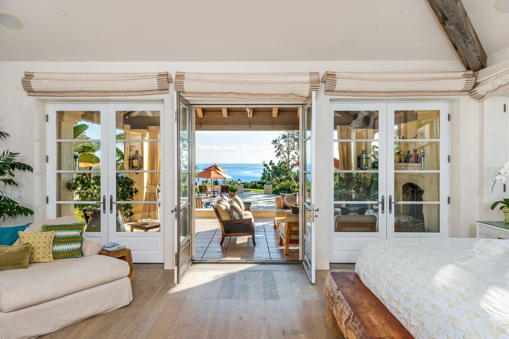 The master bedroom is a suite with a fireplace and french doors that open outside.