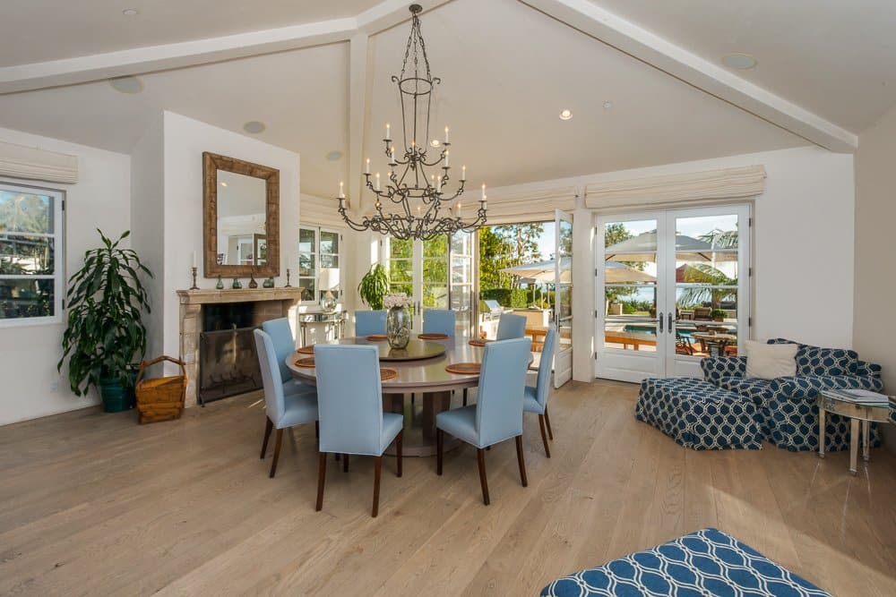 The nearby dining room also has gorgeous views of the ocean, a chandelier, and fireplace.