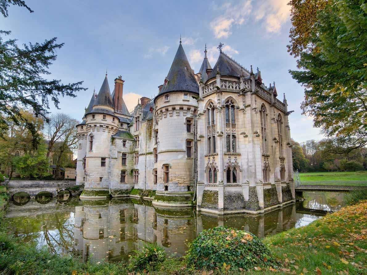 A moat-turned-water feature surrounds the main structure, but there's no drawbridge here — two bridges allow visitors access.