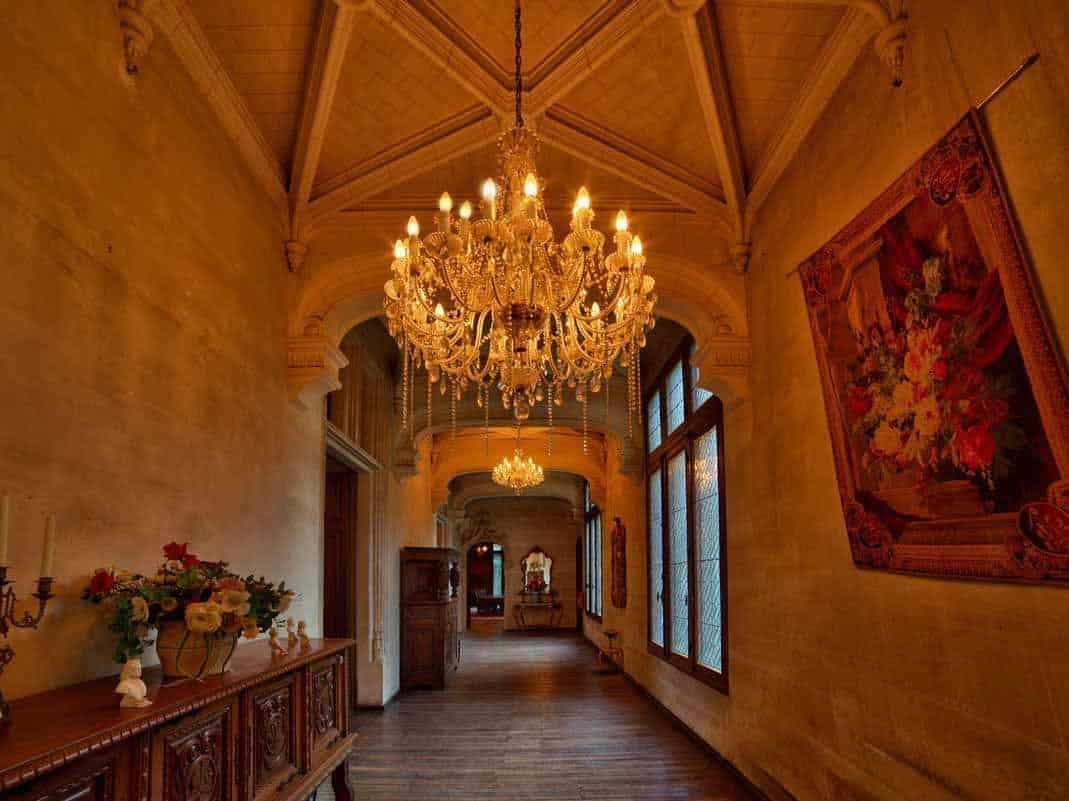 The original stonework paired with exquisite chandeliers and rich tapestries combine to create a hallway that is a treat to walk through.