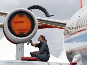 A mechanic checks the engine of a VFW 61