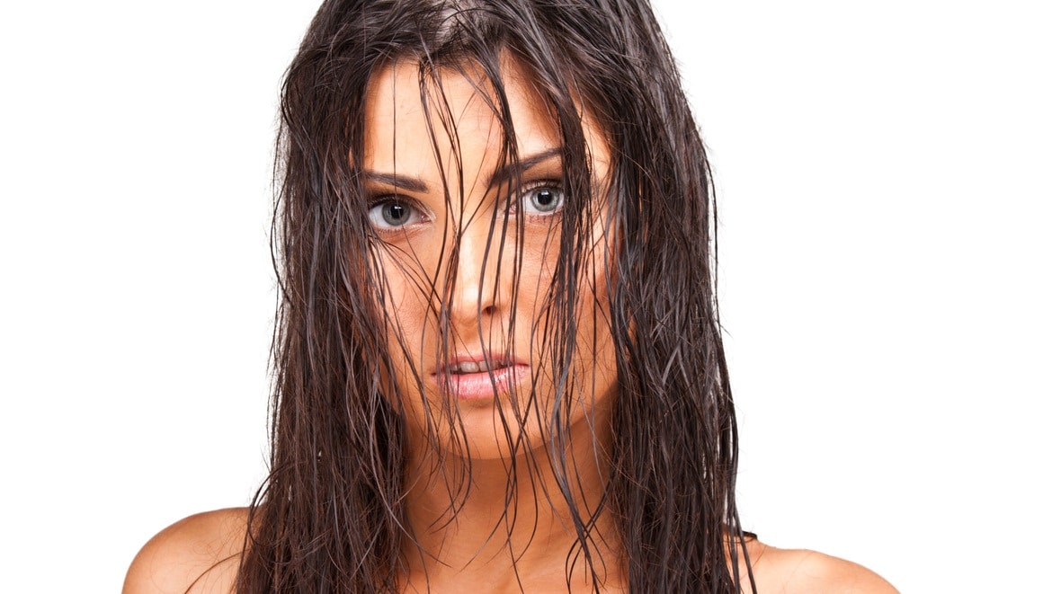 Fashion shoot of a young woman with wet hair on her face