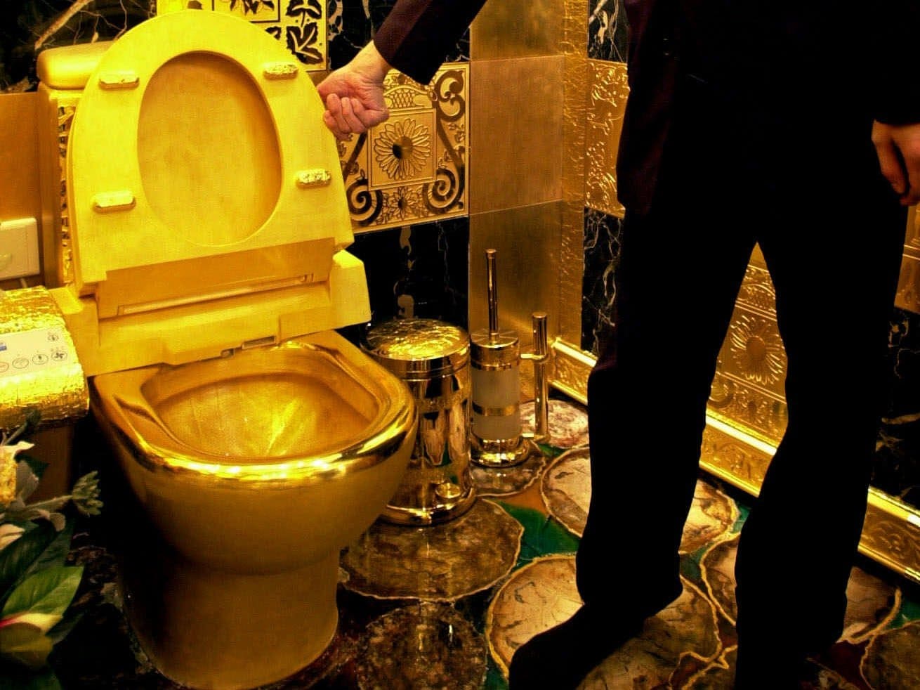 A staff member of the 3D-Gold jewelry store in Hong Kong shows off a solid gold toilet to reporters Thursday, Feb. 22, 2001. The shop owner says he was inspired by the writings of the Russian communist Vladimir I. Lenin, who wanted to build public toilets of gold after the triumph of socialism. (AP Photo/Vincent Yu )