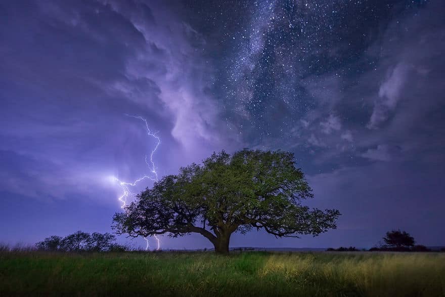 A cloud-to-ground lightning bolt strikes over Albany, Texas as the Milky Way shines above.