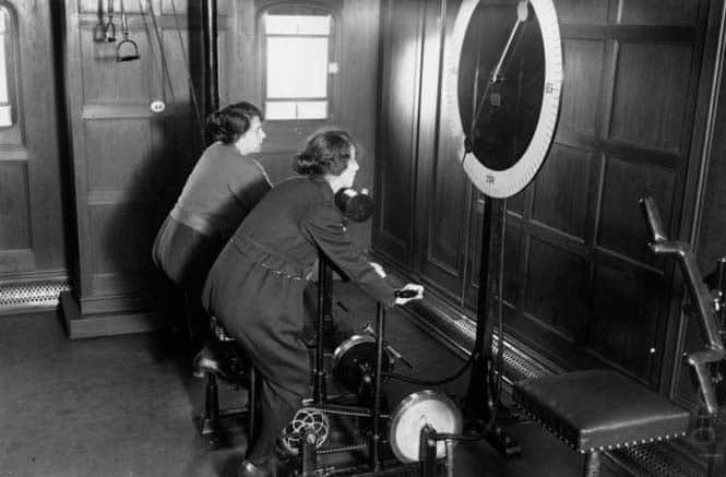Two women using the cycle machine in the gym on board the Homeric Liner, taken over from the Germans by White Star.   (Photo by Topical Press Agency/Getty Images)