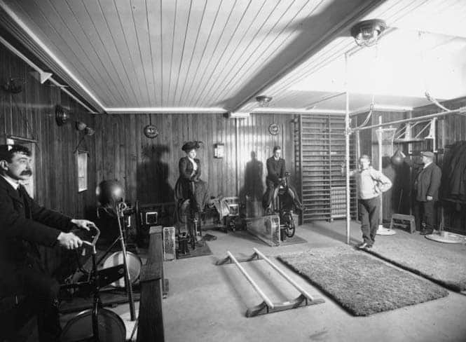 21st February 1911:  Edwardians riding exercise bikes whilst wearing day clothes in a gymnasium on board the Cunard line liner, Franconia RMS.  (Photo by Topical Press Agency/Getty Images)