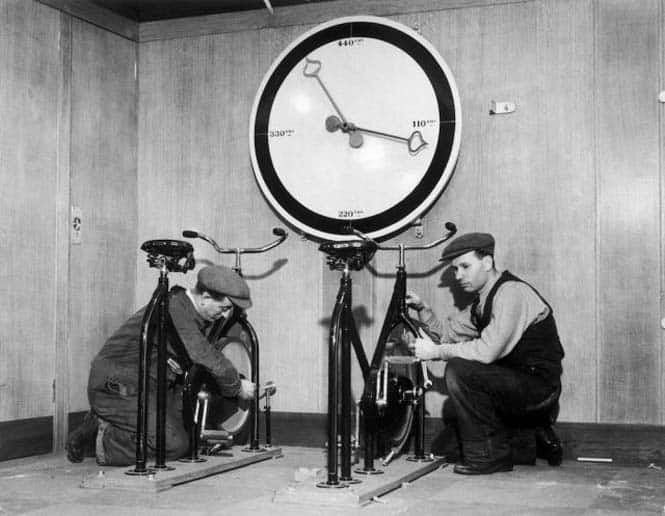 Around 1932, at the time of the installation of the English liner QUEEN MARY, workmen in the gymnasium of the ship are setting up exercise bikes with an enormous meter indicating the distance covered. Vers 1932, au moment de l'aménagement du paquebot anglais QUEEN MARY, des ouvriers mettent en place dans le gymnase du navire, des vélos d'appartement avec un énorme compteur indiquant la distance parcourue.