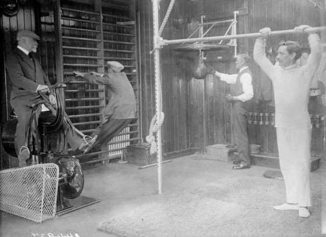 Passengers working out in the gym of the Cunard cruise liner Franconia, which was destroyed by a U-boat in 1916. Amongst the equipment is a punchbag and an early cycling machine.   (Photo by Topical Press Agency/Getty Images)