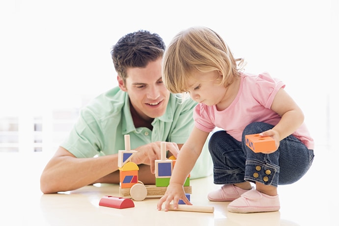 Father and daughter indoors playing and smiling