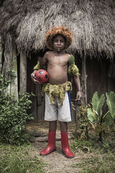 Abinus Kuban, 10, holds a ball, which he plays with his friends. Children of Arigaram village, where he lives, use secondhand clothes every day and wear "kotekas" (penis sheaths) only for cultural festivals and folk dances.  Arigaram village, West Papua Province.