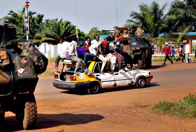 A packed taxi drives past a French checkpoint in Bangui, Central African Republic, Monday Dec. 16, 2013. Over 1600 French troops have been deployed to the country in an effort to put an end to sectarian violence.  More than 600 people have been killed since Anti-Balaka launched a strike over Bangui last week before being pushed back. (AP Photo/Jerome Delay)