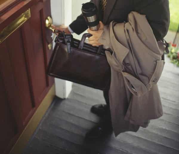 Businessman unlocking front door to house