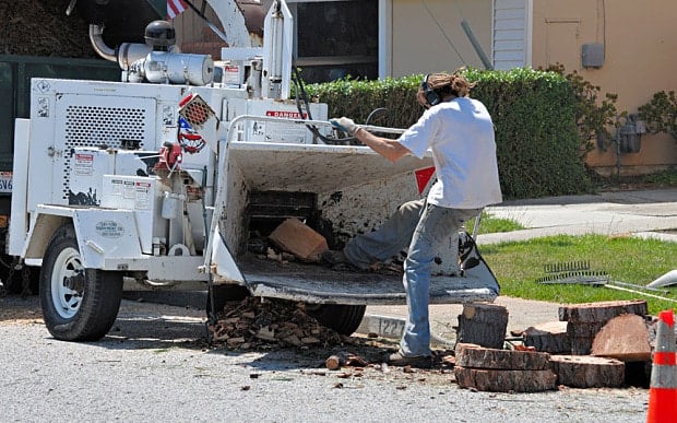 BBW345 worker trying to kick wood into a chipper in an unsafe and unprotected way (how not to use a wood chipper)