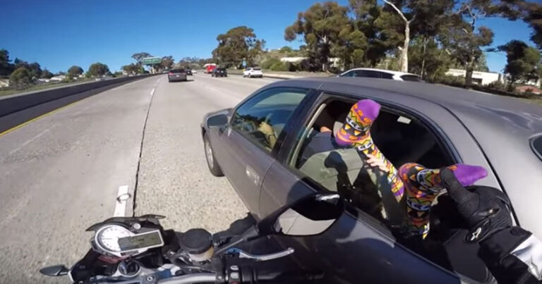 Μοτοσικλετιστής ακουμπάει τα πόδια κοπέλας που έχει βγάλει έξω από το παράθυρο.