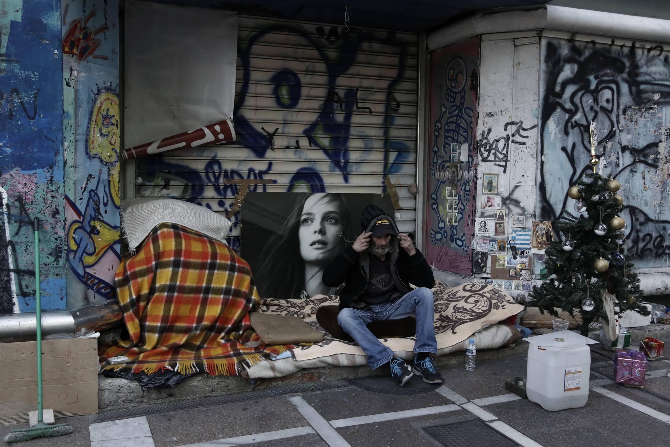 Ένας άστεγος άντρας φτιάχνει την κουκούλα από το πανωφόρι του, στο κέντρο της Αθήνας, Κυριακή 13 Δεκεμβρίου 2015. ΑΠΕ-ΜΠΕ/ΑΠΕ-ΜΠΕ/ΓΙΑΝΝΗΣ ΚΟΛΕΣΙΔΗΣ