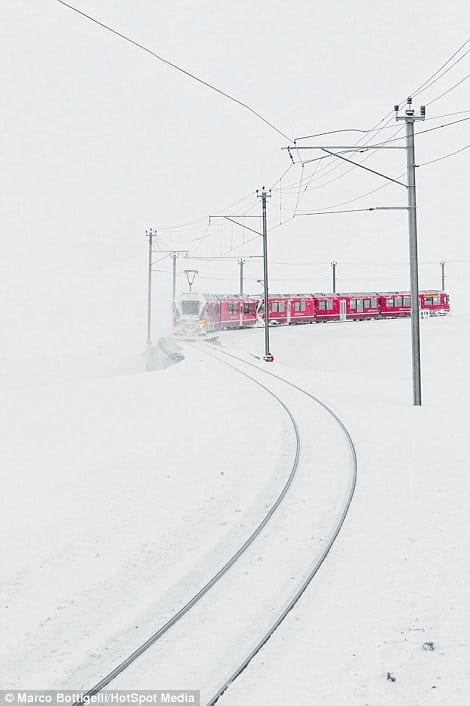 31F2FE7E00000578-0-The_red_of_the_train_is_visible_through_snowy_scenes_on_the_Bern-a-40_1457355321076
