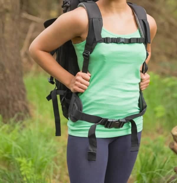 Pretty woman standing in a forest on a hike