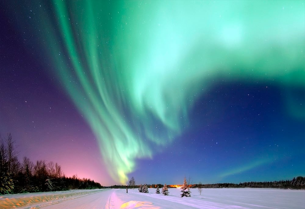 The Aurora Borealis, a luminous phenomenon, otherwise called the 'Northern Lights' is viewed over the Arctic, photographed by members of the British Nares expedition. Their ship can be seen trapped in sea ice in the bay. (Photo by Hulton Archive/Getty Images)