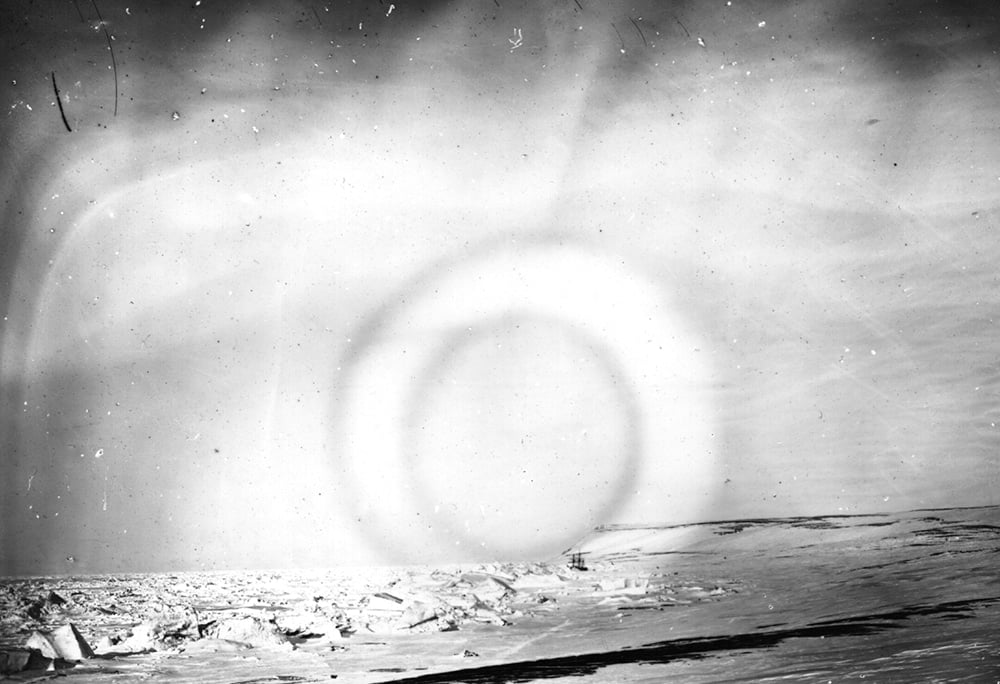 The Aurora Borealis, a luminous phenomenon, otherwise called the 'Northern Lights' is viewed over the Arctic, photographed by members of the British Nares expedition. Their ship can be seen trapped in sea ice in the bay. (Photo by Hulton Archive/Getty Images)