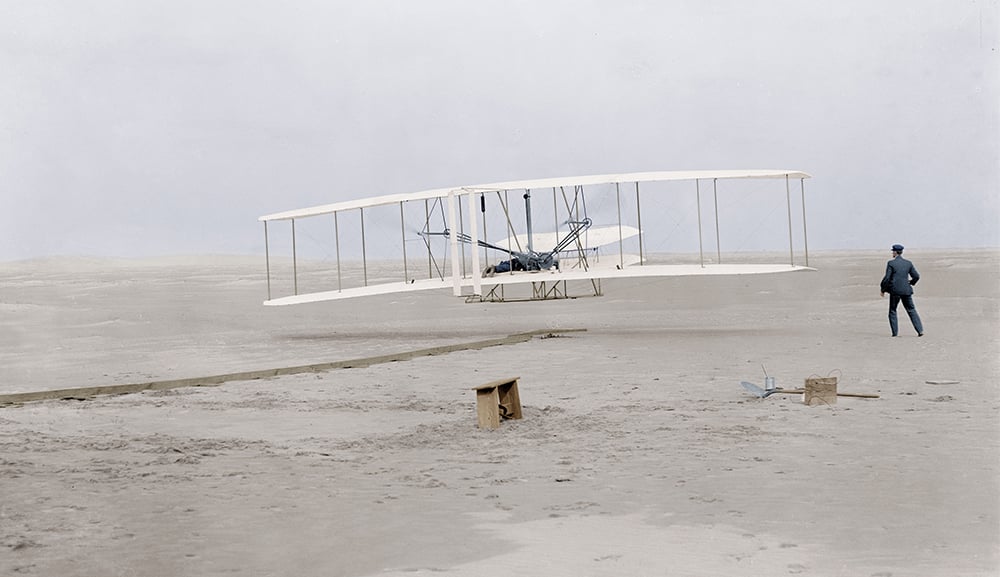 L'aviateur Orville Wright (1871-1948) avec son avion biplan Flyer sur la plage de Kill Devil Hills a Kitty Hawk, Caroline du Nord, lors de son 1er vol le 17 decembre 1903 sur une distance de 120 pieds (36,5 metres) pour une duree de 12 secondes, son frere Wilbur Wright se tient debout a droite de l'appareil  ---  first flight  of Orville Wright (1871-1948) at Kill Devil Hills, Kitty Hawk, North Carolina december 17, 1903 (120 feet in 12 seconds), his brother Wilbur Wright stand on the right