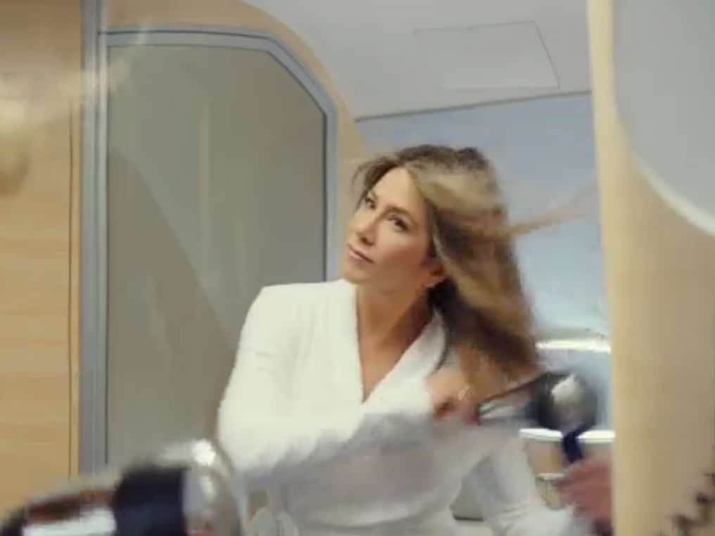 the-commercial-opens-with-aniston-blow-drying-her-hair-after-an-in-flight-shower