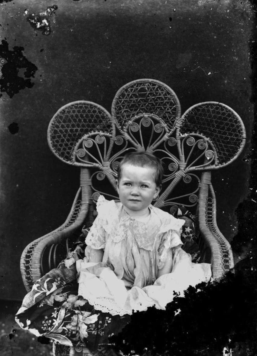 statelibqld_2_196311_portrait_of_an_unidentified_baby_sitting_on_an_elaborate_cane_chair_1900-1910-850x1175