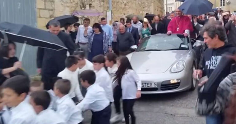 Παιδιά τραβούν με σχοινιά ιερέα μέσα σε Porsche που κάνει είσοδο σε τελετή εγκαινίων