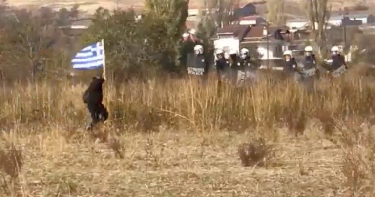 H ΕΛ.ΑΣ προσπαθεί να κλείσει τον δρόμο σε άντρα με την ελληνική σημαία και αυτός τους γλεντάει