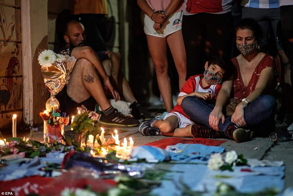 36128058 8989197 mourners sit in contemplation next to a shrine where candles wer a 30 1606377996951