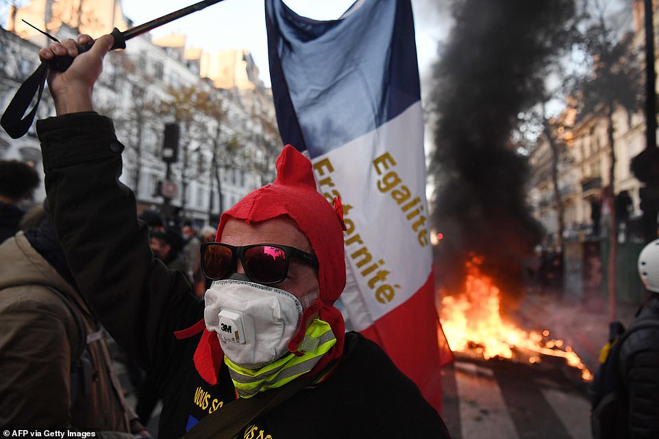 36207888 8996437 a protester in paris holds a french flag during a demonstration a 38 1606598227991