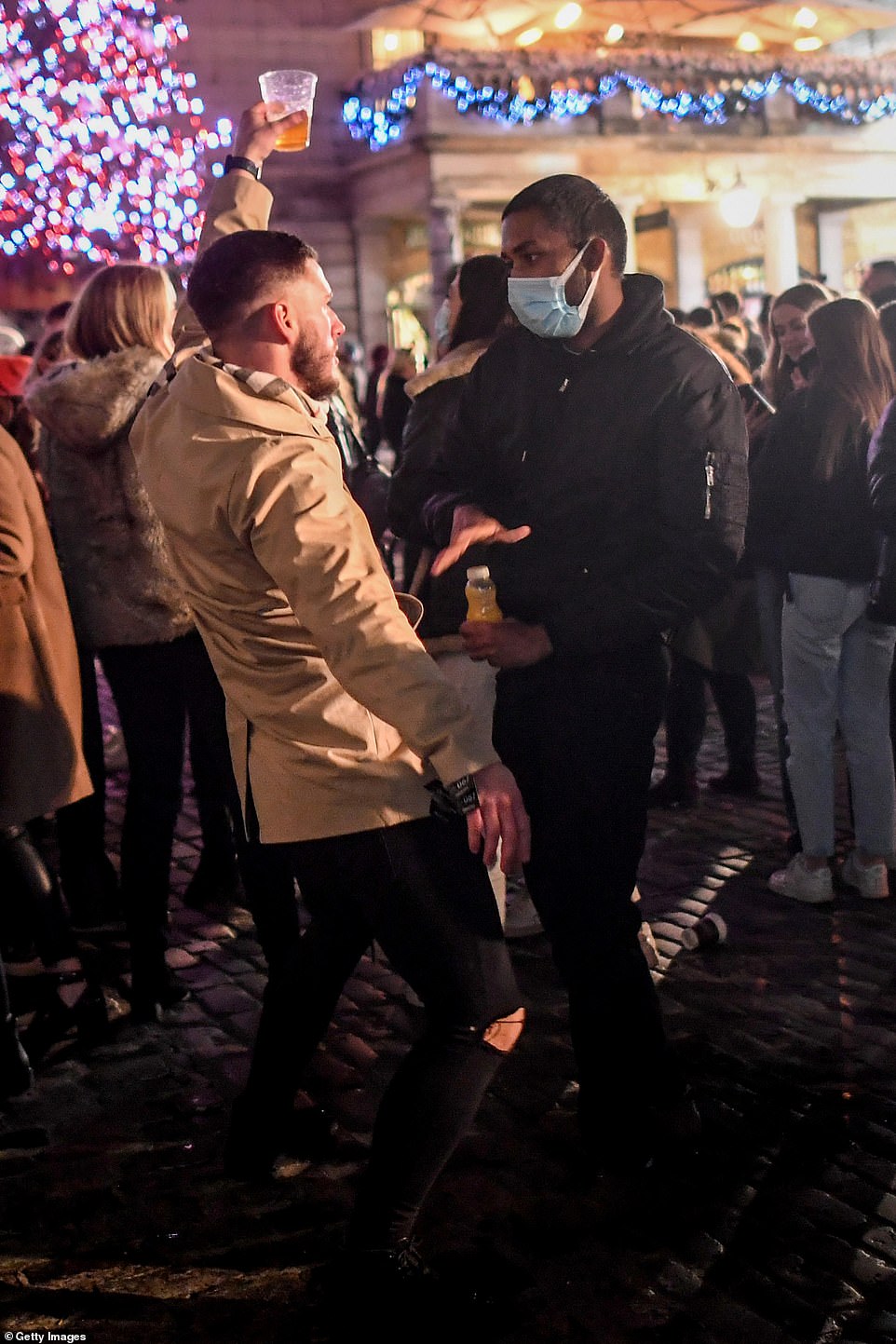 36494538 9021981 a man holding a pint dances in front of a man wearing a mask in a 20 1607244995609