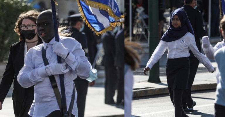 Σύνταγμα: Μαύρος σημαιοφόρος και παραστάτρια με μουσουλμανική μαντήλα