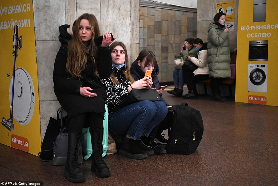 54591269 10545977 girls hold their mobile phone as they take refuge in a metro sta a 24 1645692072698
