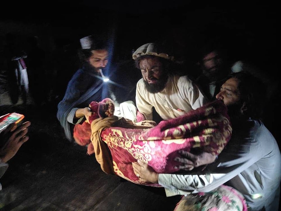 59375499 10940771 a man carries a body wrapped in a rug after the tremors struck t a 26 1655880134359