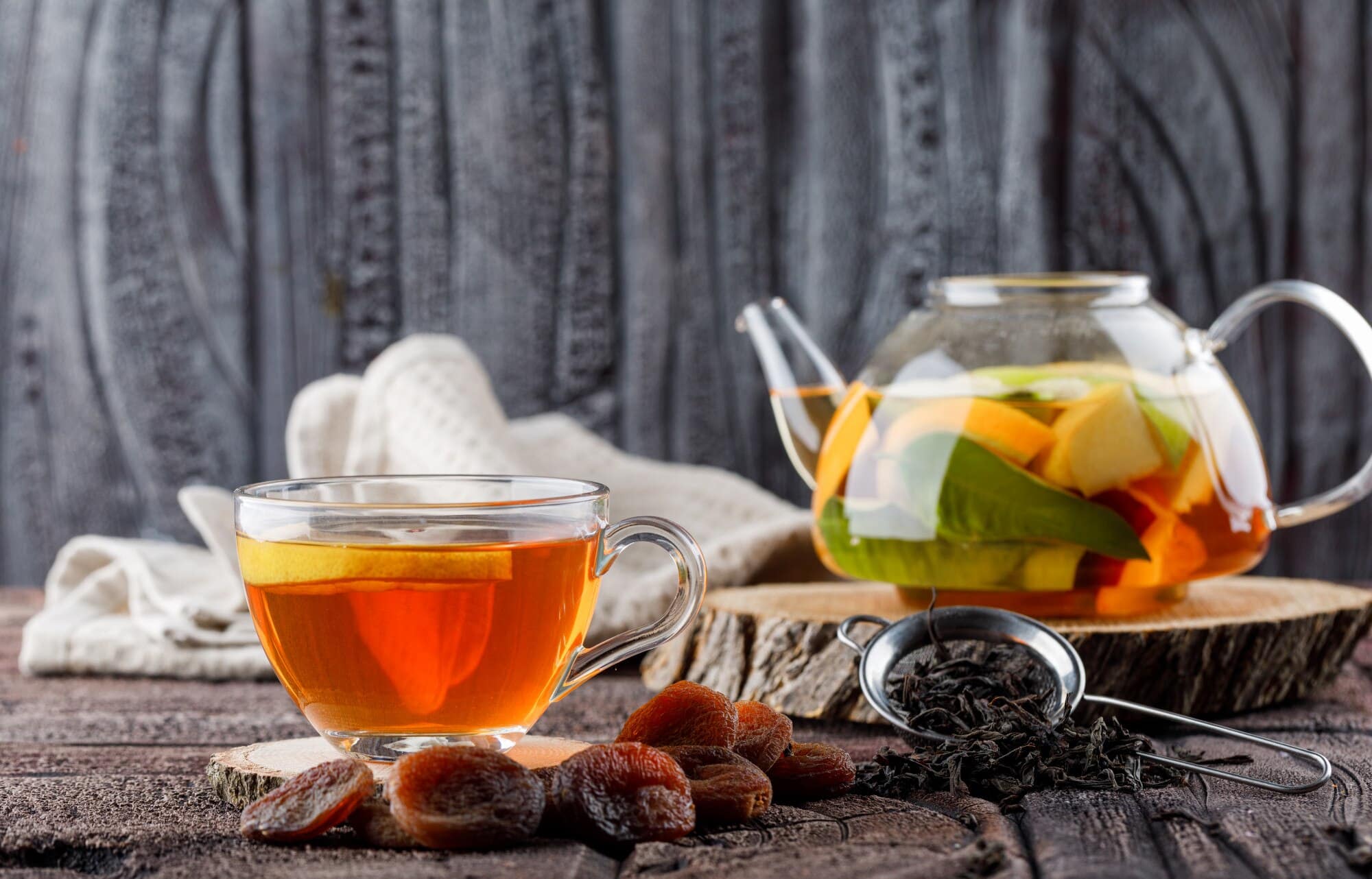 fruit infused water teapot with tea dried apricots wood kitchen towel container side view stone tile wooden surface 176474 6362