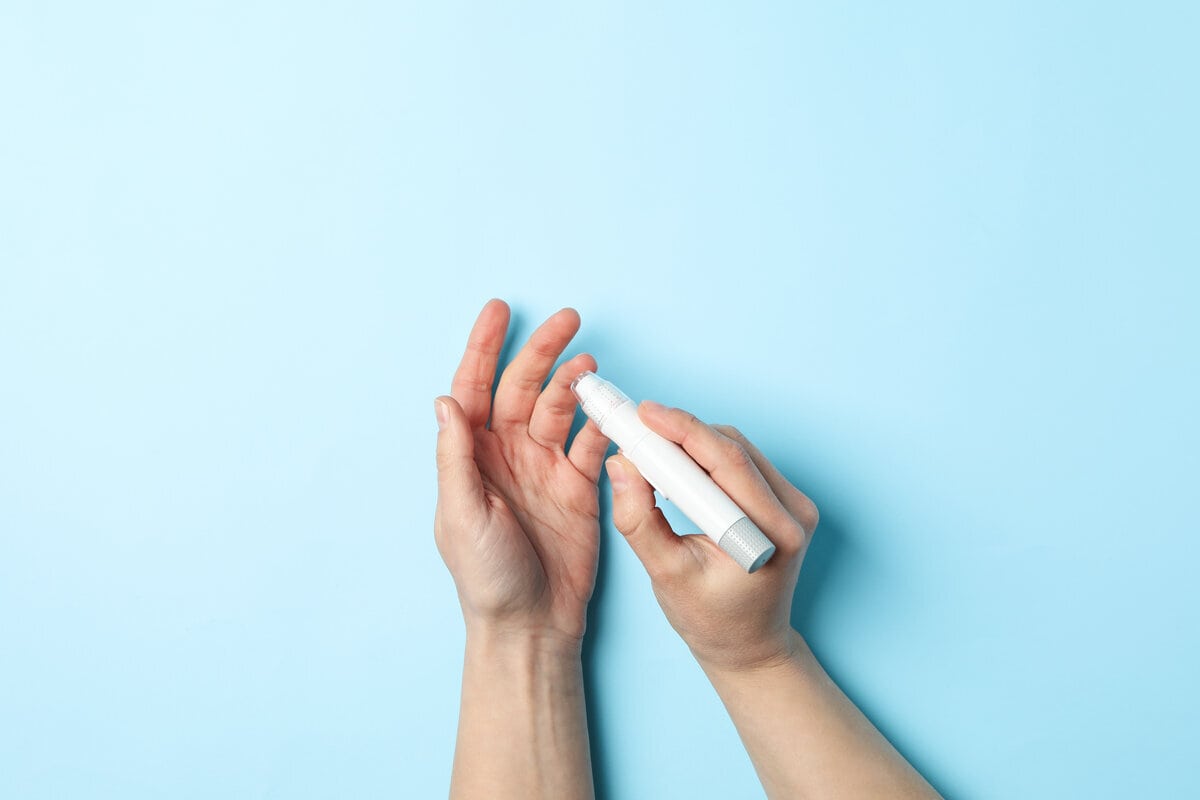 rsz female checking blood sugar level blue background