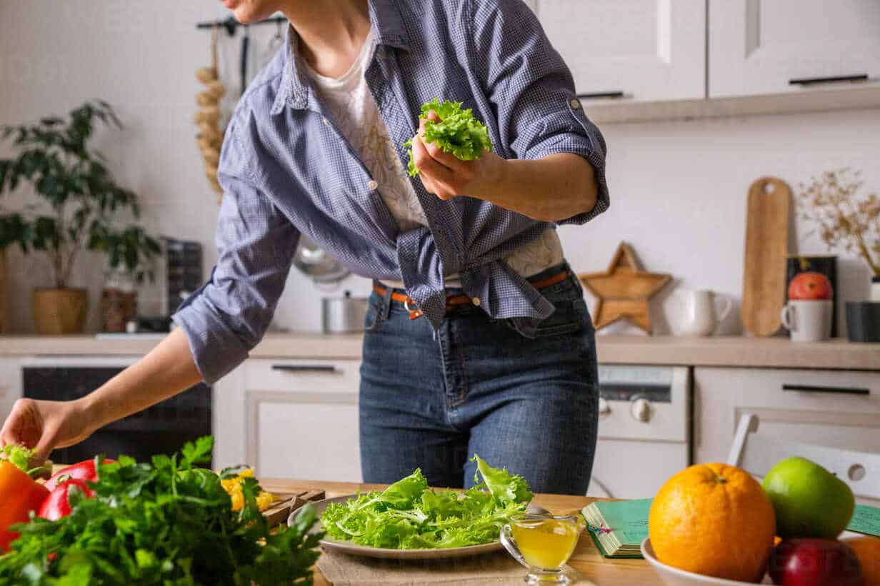 young and beautiful housewife woman cooking in a white kitchen cavf80154