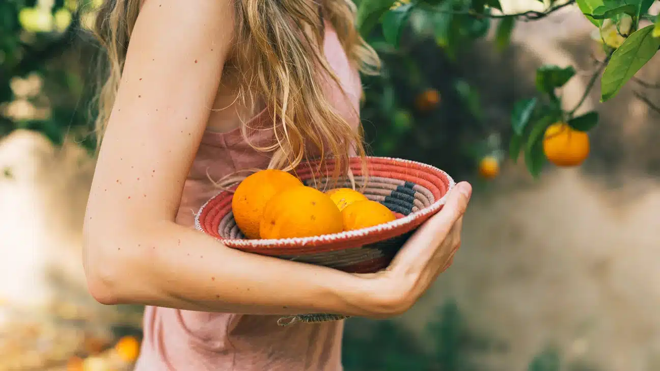 female carrying basket of oranges 1296 728 header
