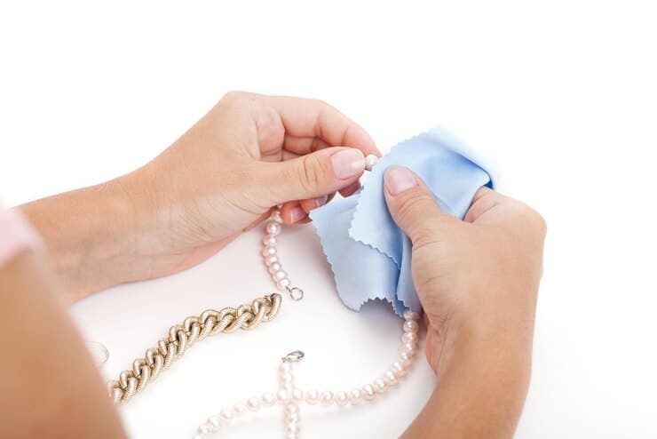 woman is cleaning necklace with blue cloth 924511 677