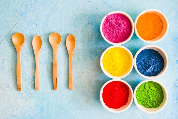 wooden spoon with holi color powder white bowl painted blue backdrop 23 2147949163