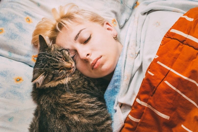 cat sleeping with owner masik0553 shutterstock