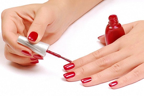 woman applying nail polish thumb