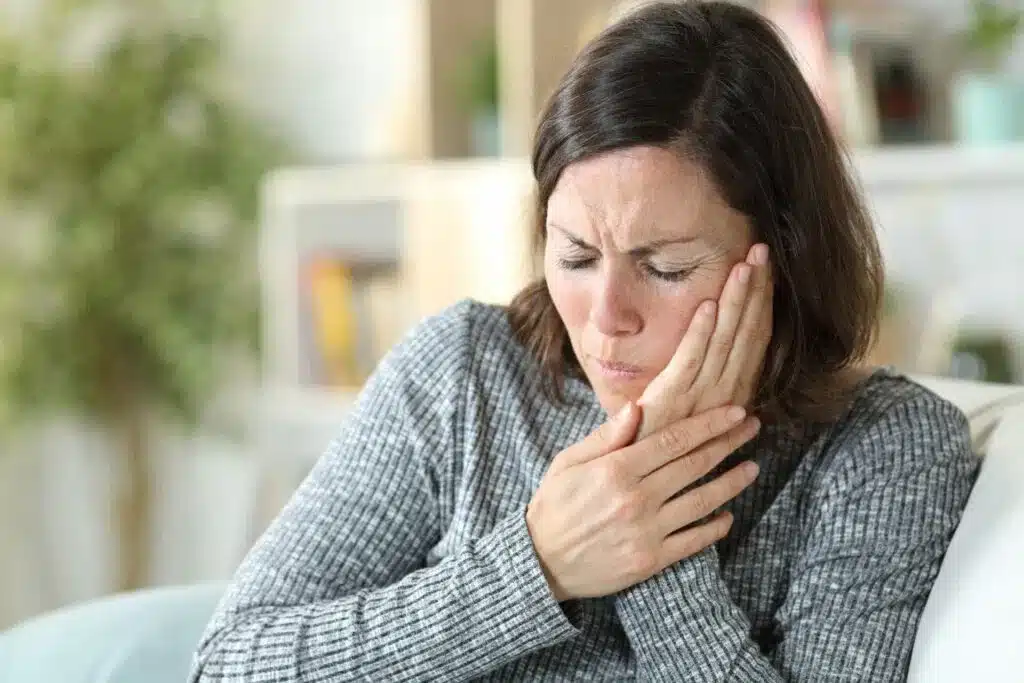 woman sitting at home with jaw p
