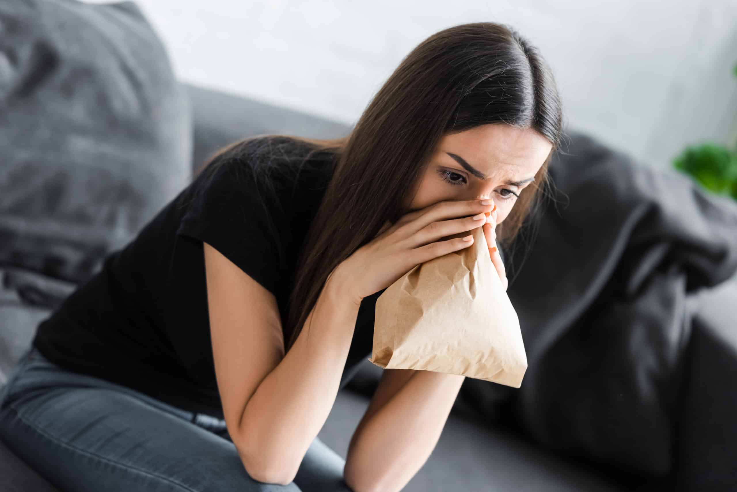 young woman breathing into paper bag while sufferi 2021 08 30 01 46 36 utc scaled 1