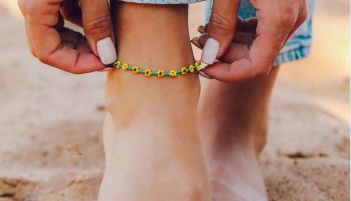 fingers touching the beautiful flower anklets