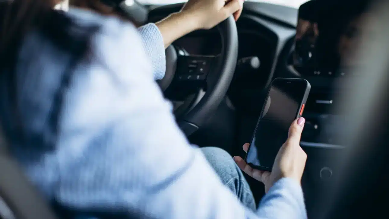 a928c108 woman using phone while driving car
